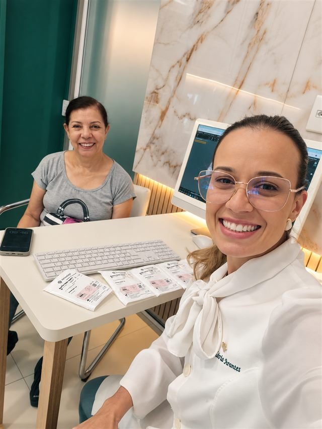 Dra. Flávia Arantes acolhendo uma paciente na mesa de atendimento
